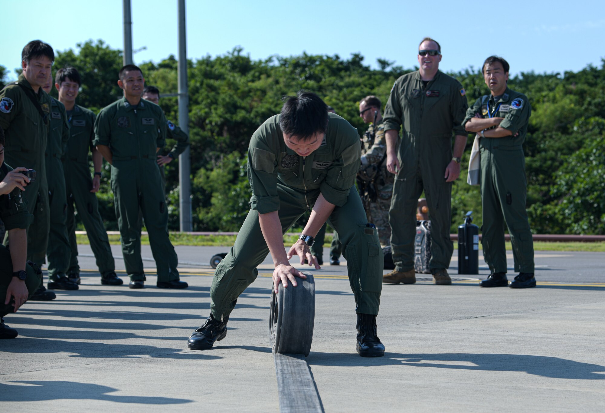 A Japan Air Self-Defense Force service member rolls a fuel hose during Rescue Flag Okinawa 2023 at Kadena Air Base, Japan, Oct. 27, 2023.