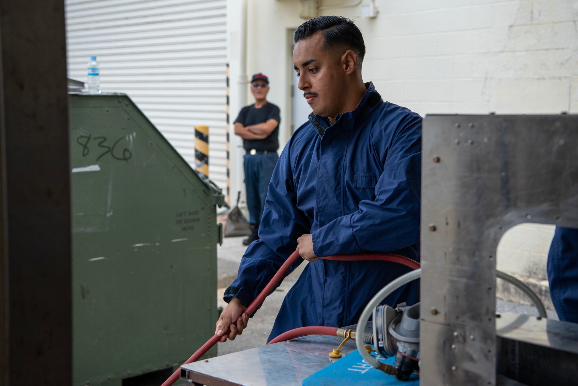 Staff Sgt. Allen Gonzales pulls on breathing mask hose