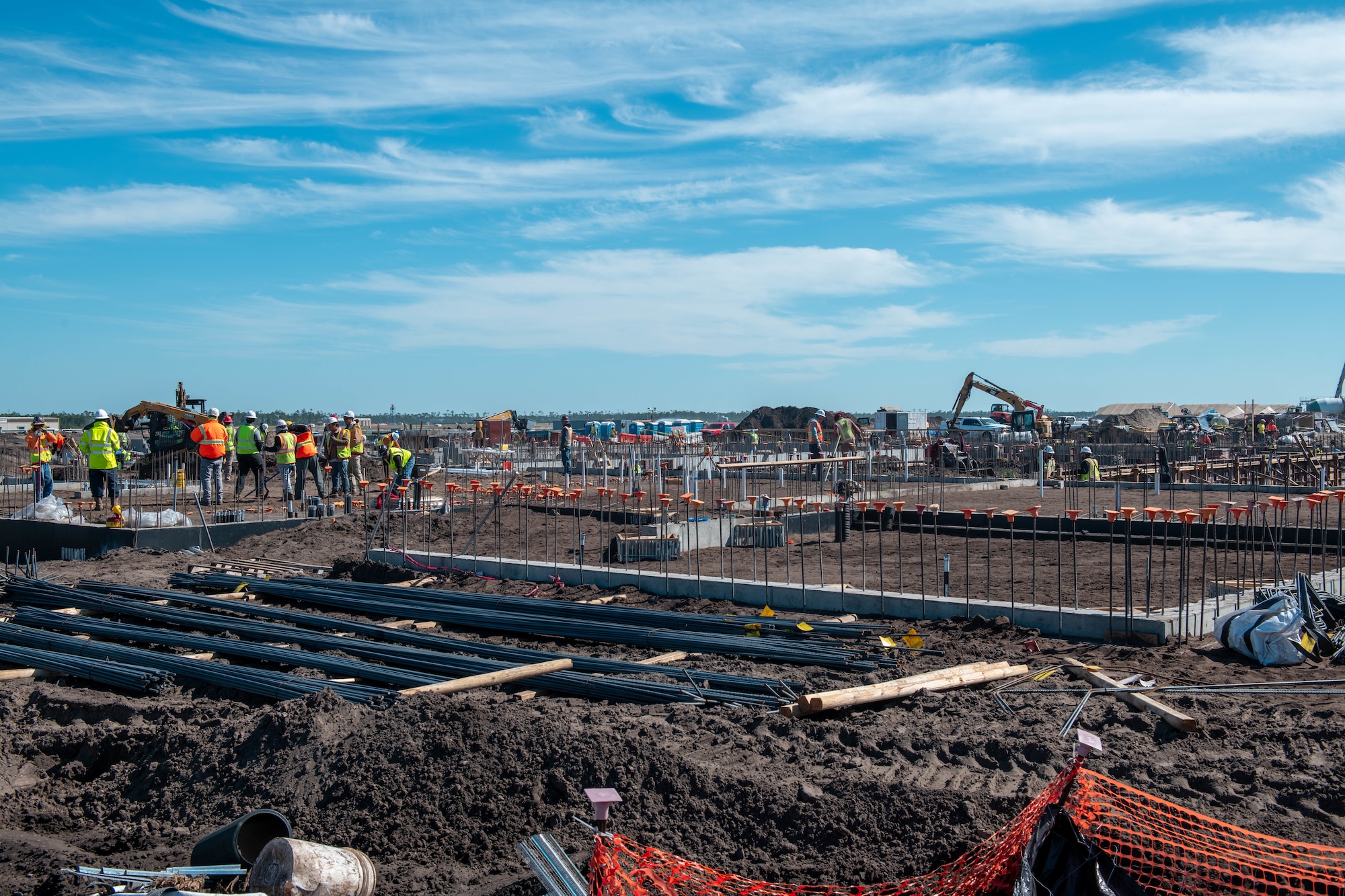 A wide-angled shot of a construction site with construction workers scattered throughout the site.