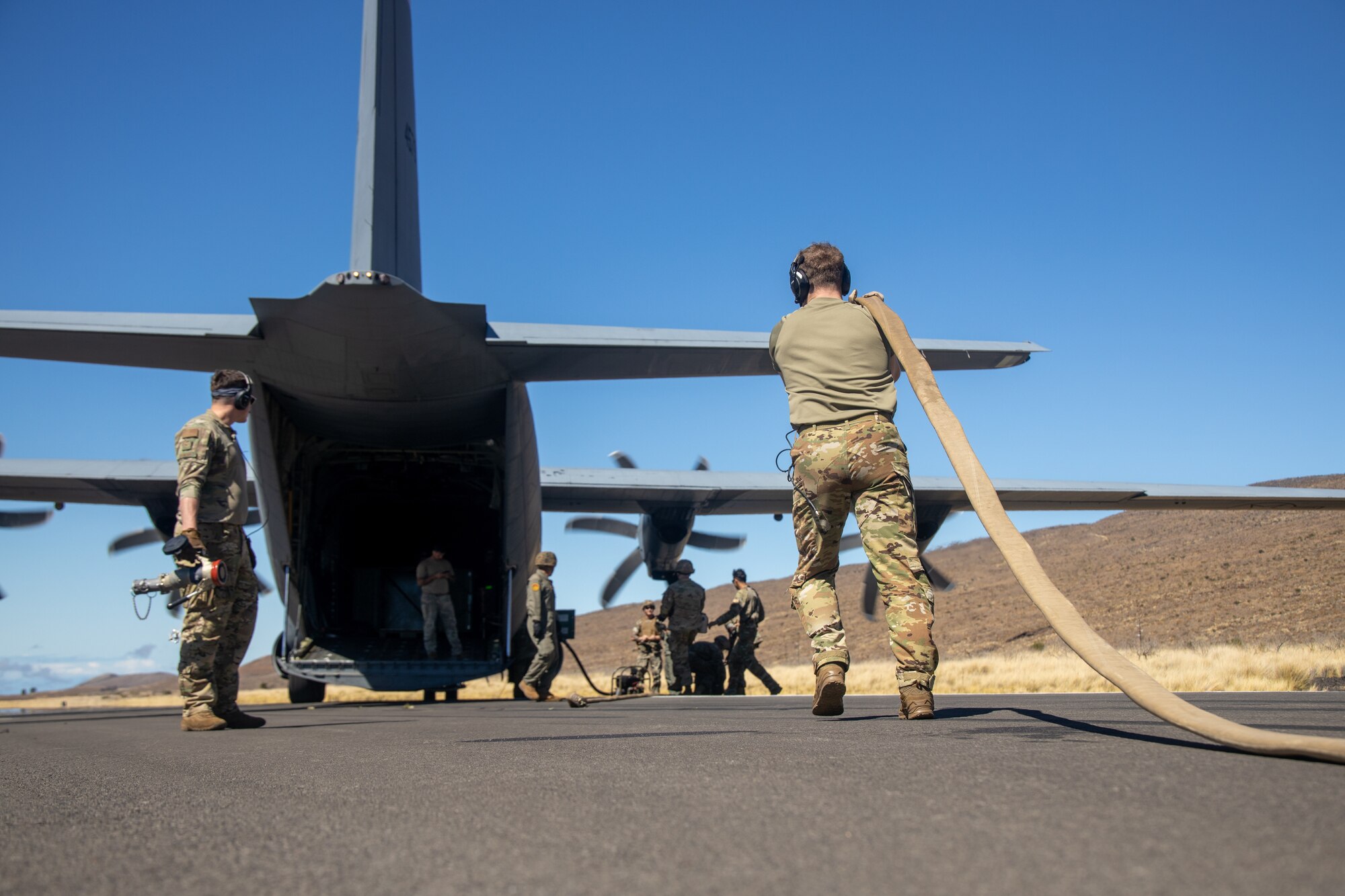 An Airman holds a fuel hose.