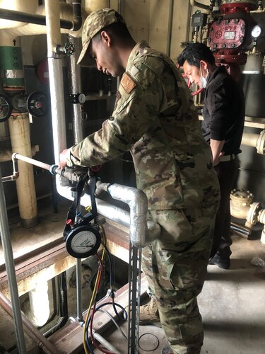 two people check a water system