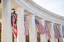 Large U.S. flags are hung from the top of an amphitheater.