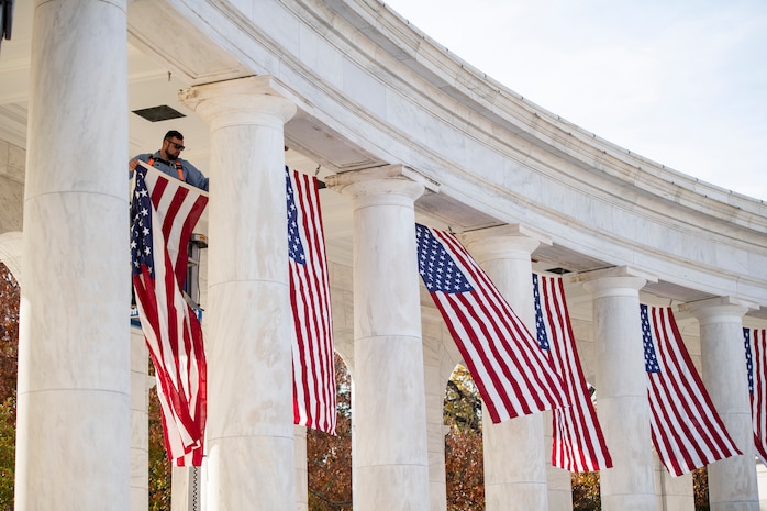 Large U.S. flags are hung from the top of an amphitheater.