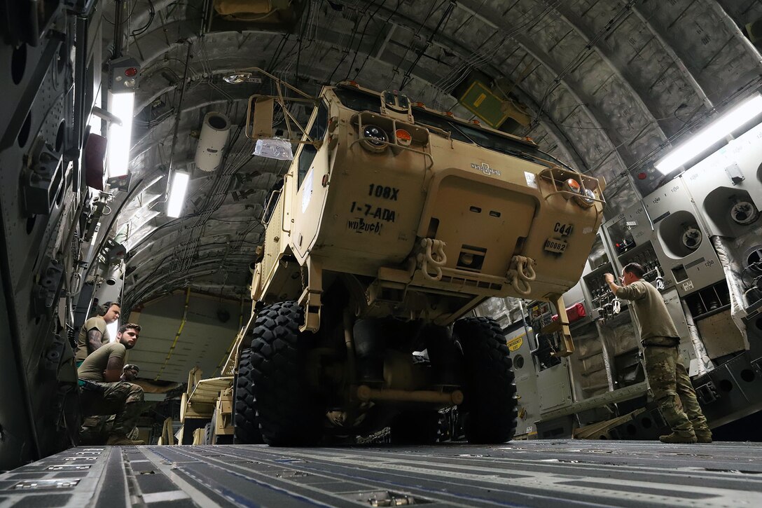Soldiers and airmen load a Patriot Launching Station on a C-17.