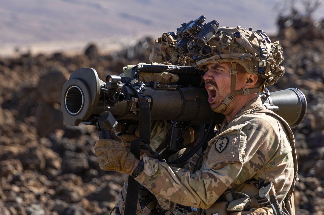 A soldier yells as he fires a weapon.