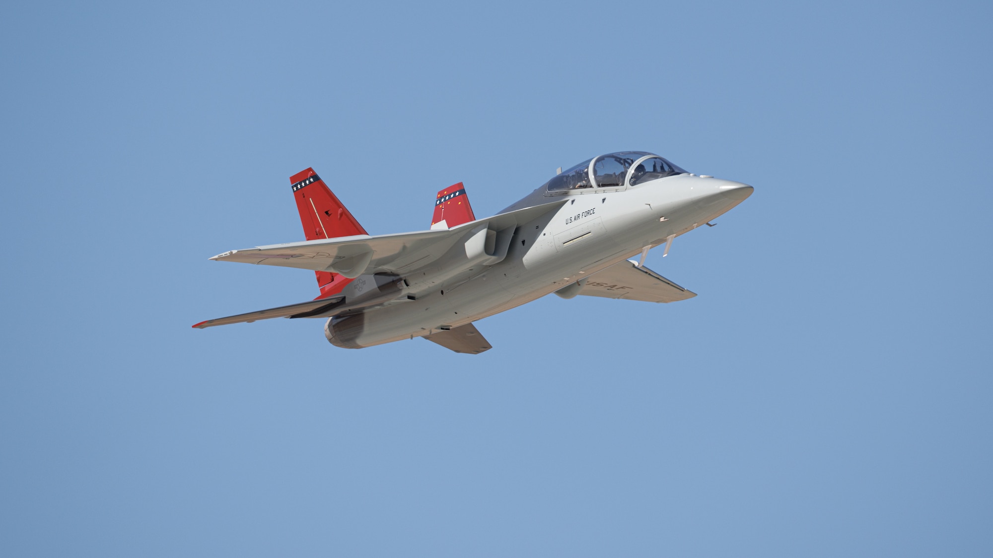 The first T-7A Red Hawk, piloted by USAF test pilot Maj. Jonathan “Gremlin” Aronoff and Boeing test pilot Steve “Bull” Schmidt, soars over Edwards Air Force Base, California, Nov. 8, prior to arrival. The T-7A will replace the 1960s-era T-38 aircraft by providing advanced pilot training capabilities for aviators learning to fly both tactical and bomber aircraft. (Air Force photo by Joshua McClanahan)