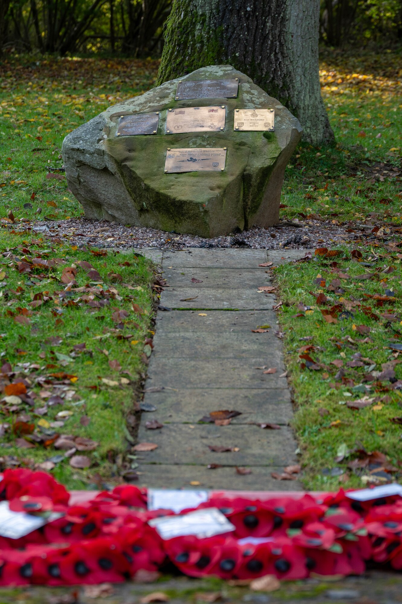 Poppy wreaths lay at the base of a memorial.
