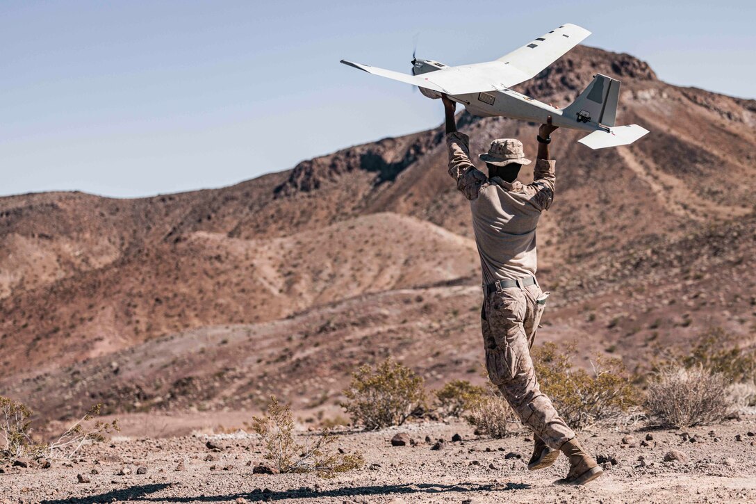 A Marine launches a small unmanned aircraft.