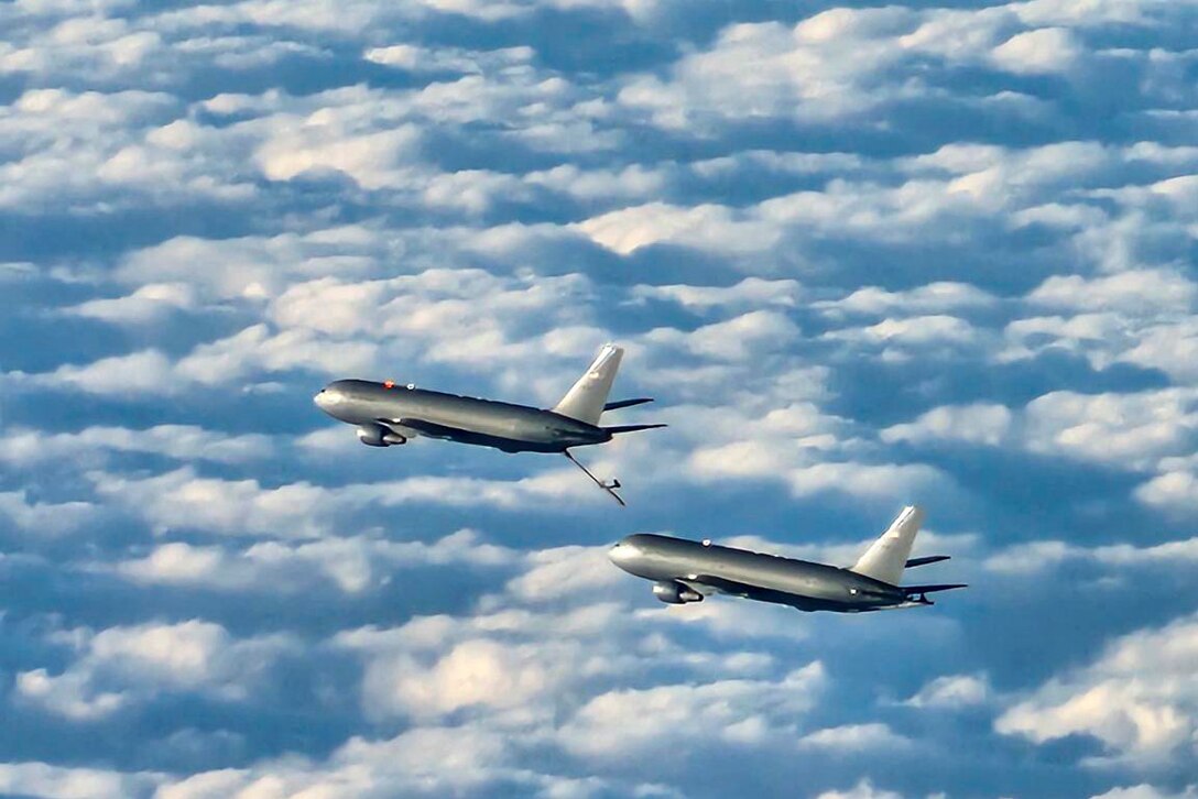 An aircraft prepares to receive fuel from another aircraft midair.