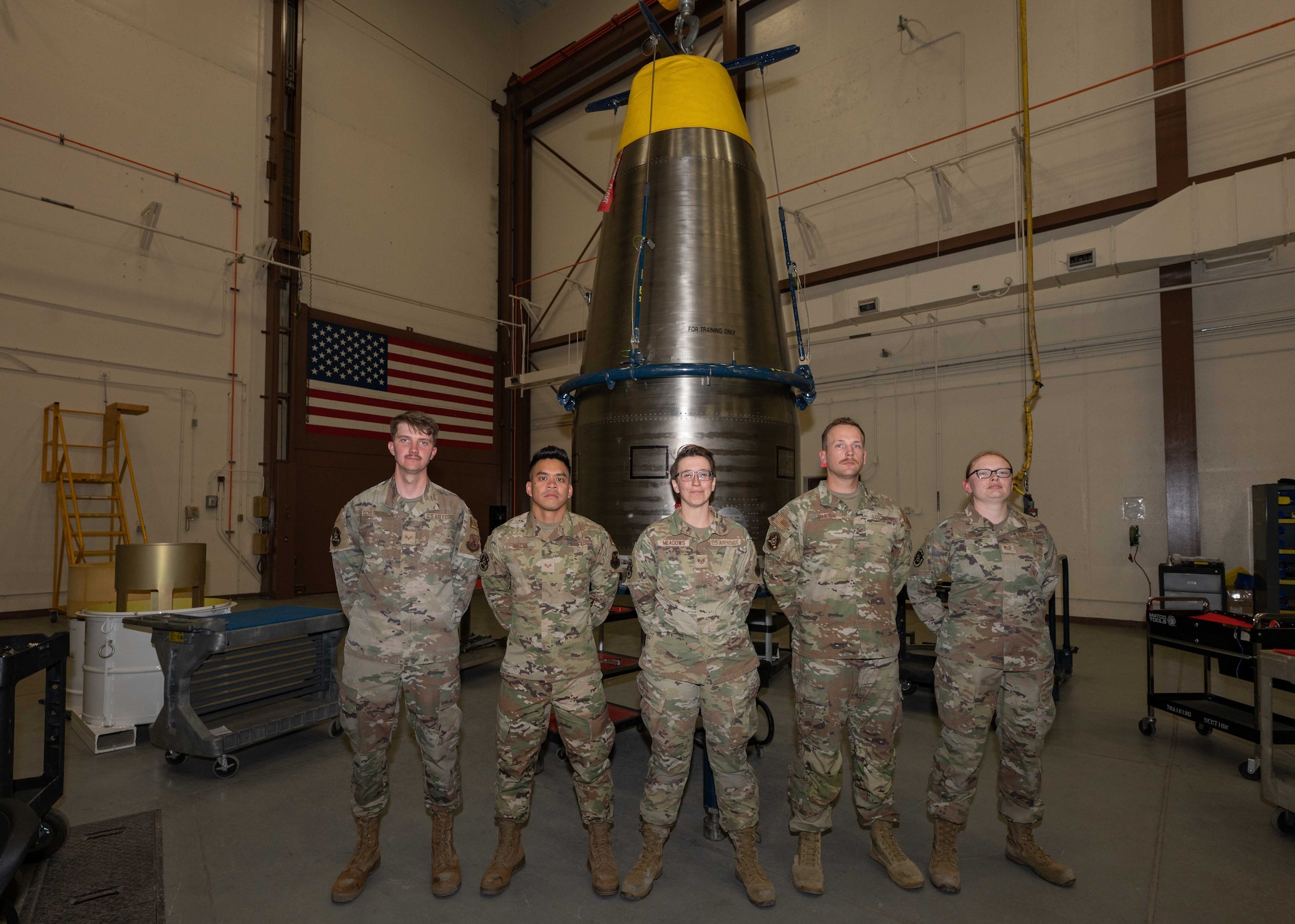 Five Airmen assigned to the 90th Munitions Squadron pose for a photo during the 2023 Global Strike Challenge, August 17, 2023, in the Weapon Storage Area on F.E. Warren Air Force Base, Wyoming. The Global Strike Challenge is a bi-annual competition between Airmen and units across Air Force Global Strike Command to foster teamwork and critical thinking. (U.S. Air Force photo by Senior Airman Sarah Post)