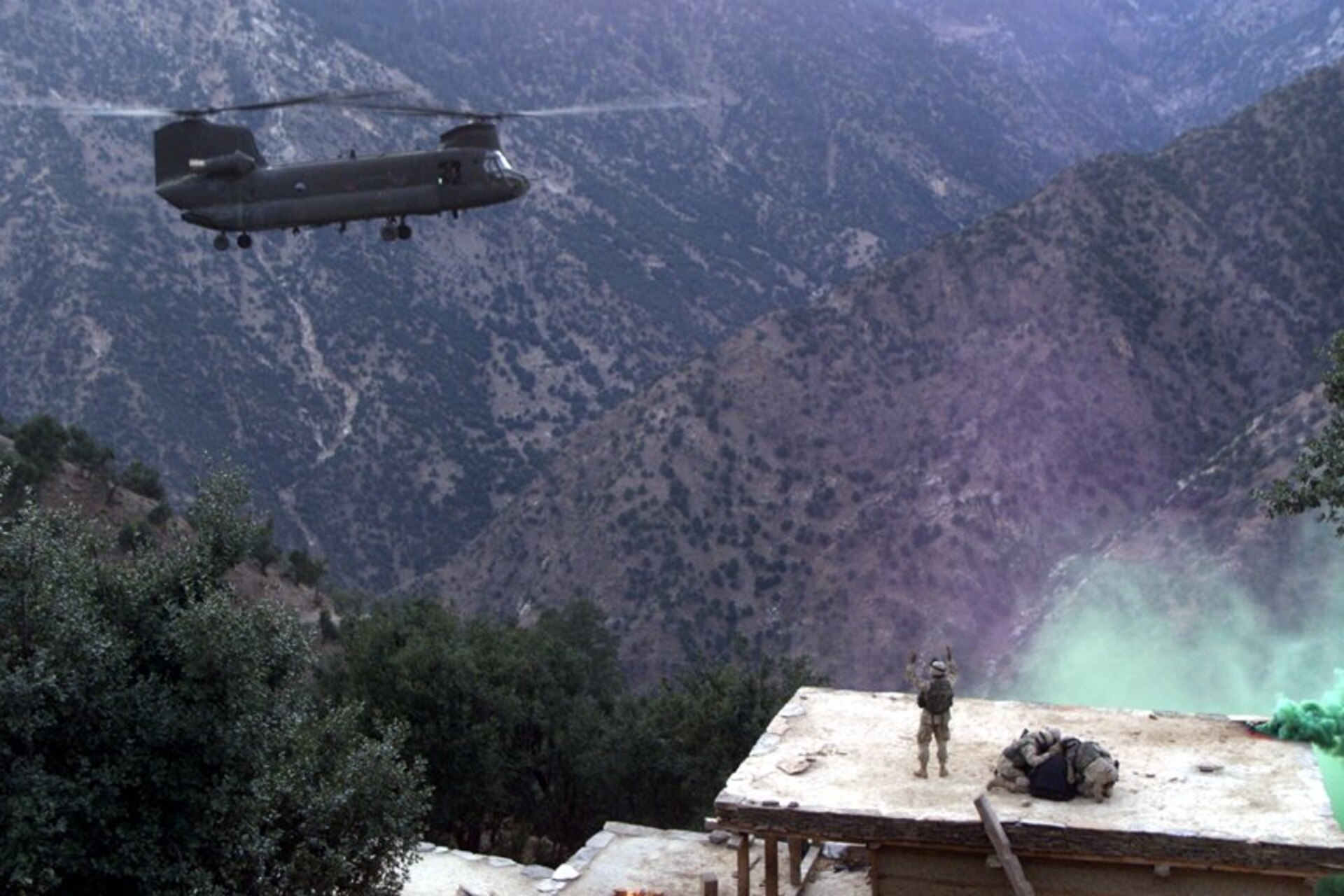 A CH-47 Chinook helicopter piloted by Chief Warrant Officer 3 Larry Murphy and Chief Warrant Officer 3 Paul Barnes of the Pennsylvania National Guard’s Company G, 104th Aviation Regiment lands on the roof of a house in northeastern Afghanistan to evacuate detainees on Nov. 10, 2003. (U.S. Army photo by Sgt. Greg Heath)
