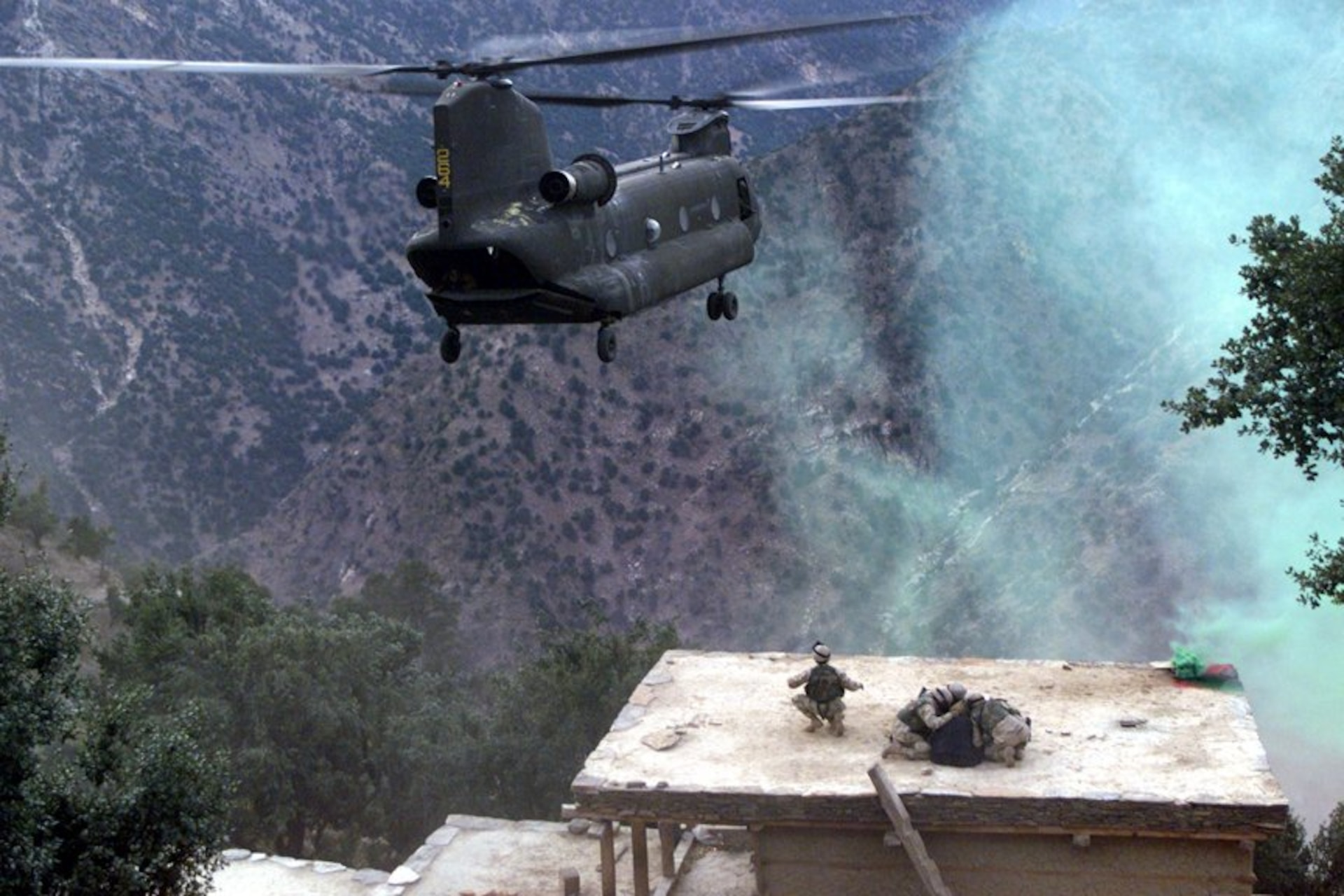 A CH-47 Chinook helicopter piloted by Chief Warrant Officer 3 Larry Murphy and Chief Warrant Officer 3 Paul Barnes of the Pennsylvania National Guard’s Company G, 104th Aviation Regiment lands on the roof of a house in northeastern Afghanistan to evacuate detainees on Nov. 10, 2003. (U.S. Army photo by Sgt. Greg Heath)