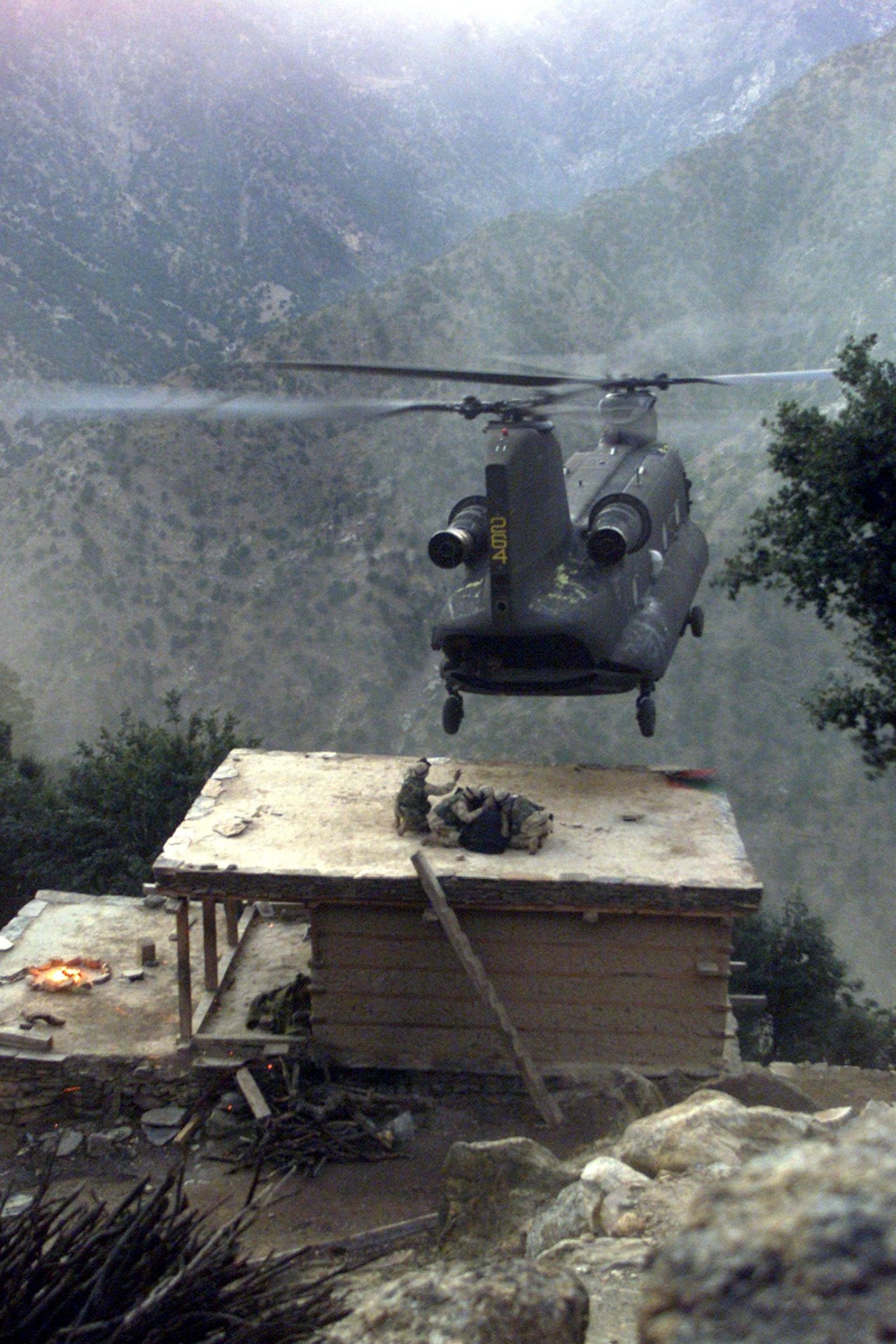 A CH-47 Chinook helicopter piloted by Chief Warrant Officer 3 Larry Murphy and Chief Warrant Officer 3 Paul Barnes of the Pennsylvania National Guard’s Company G, 104th Aviation Regiment lands on the roof of a house in northeastern Afghanistan to evacuate detainees on Nov. 10, 2003. (U.S. Army photo by Sgt. Greg Heath)