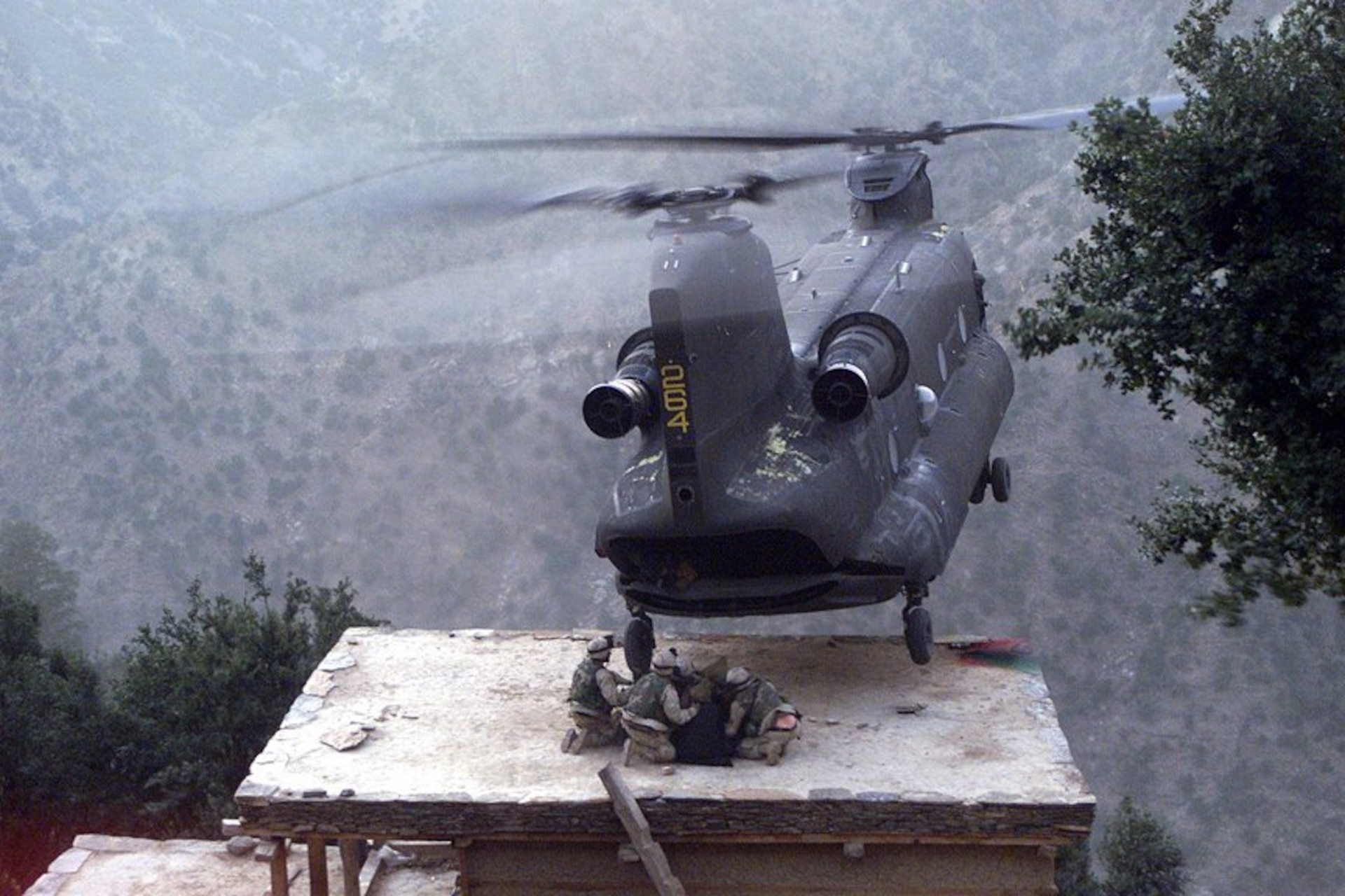 A CH-47 Chinook helicopter piloted by Chief Warrant Officer 3 Larry Murphy and Chief Warrant Officer 3 Paul Barnes of the Pennsylvania National Guard’s Company G, 104th Aviation Regiment lands on the roof of a house in northeastern Afghanistan to evacuate detainees on Nov. 10, 2003. (U.S. Army photo by Sgt. Greg Heath)