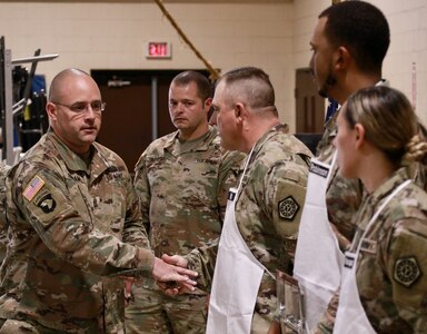 Command Sgt. Maj. Nicholaus Fordham, the command sergeant major of the 198th Combat Sustainment Support Battalion and the full-time Illinois Army National Guard logistics sergeant major, presented the coin of Chief Warrant Officer 4 Tollie Yoder, the U.S. Army National Guard food advisor, to Staff Sgt. Justin Hill of Robinson, Illinois; Spc. Jordan Robinson of Danville, Illinois; and Spc. Samantha Vazquez of Norwood, Illinois.