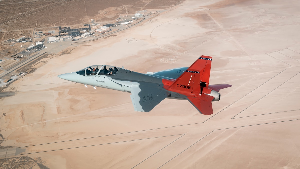 The first T-7A Red Hawk, piloted by USAF test pilot Maj. Jonathan “Gremlin” Aronoff and Boeing test pilot Steve “Bull” Schmidt, soars over Edwards Air Force Base, California, Nov. 8, prior to arrival. The T-7A will replace the 1960s-era T-38 aircraft by providing advanced pilot training capabilities for aviators learning to fly both tactical and bomber aircraft. (Air Force photo by Bryce Bennett)