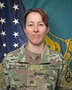 Female Soldier posed in front of two flags