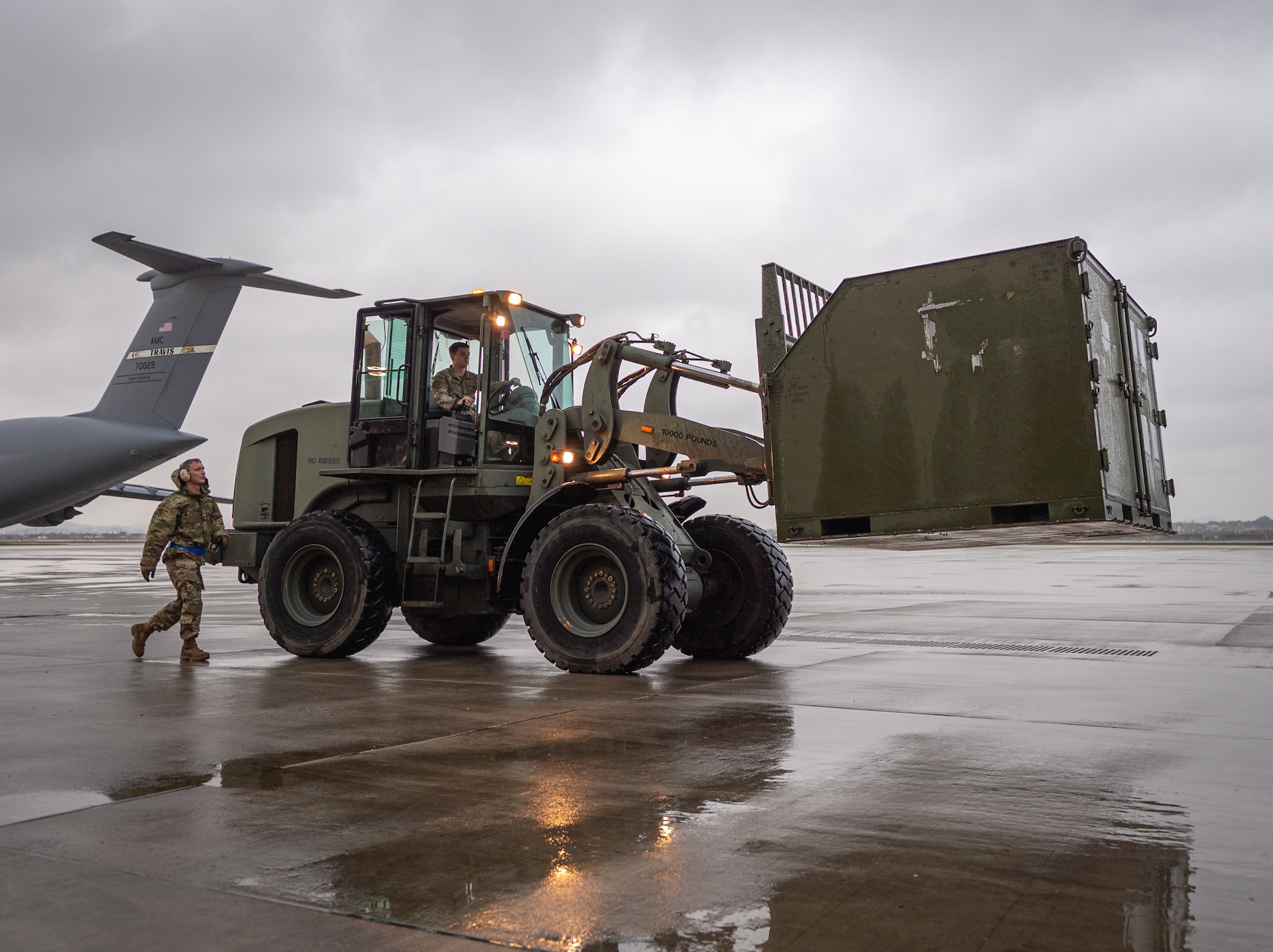 Photo of U.S. Air Force logistic Airmen transferring cargo to an aircraft.