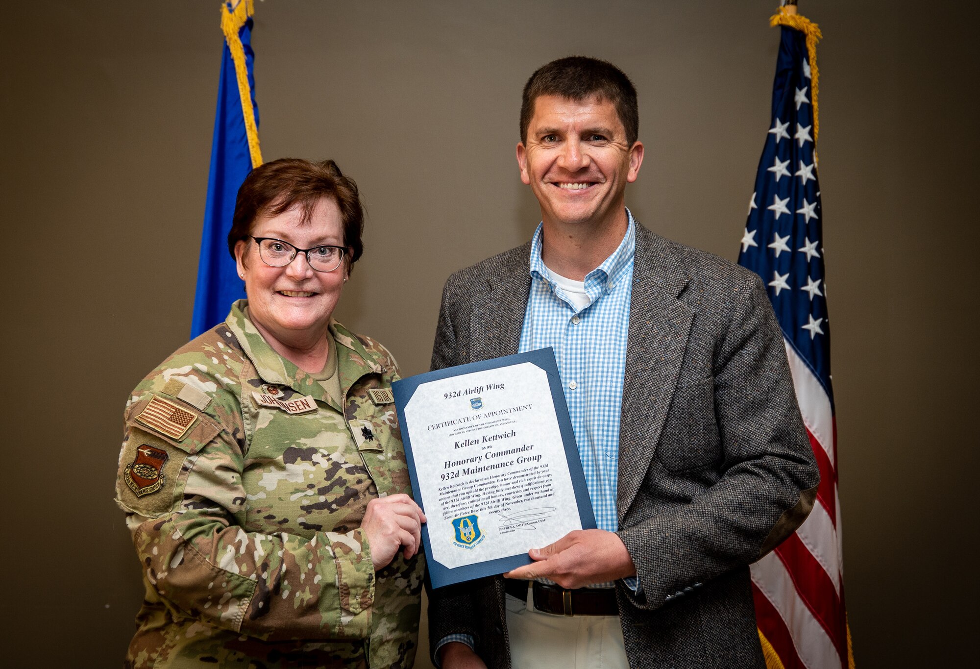 Kellen Kettwich, Principal, Scott Elementary School, and the newly instated 932nd Maintenance Group Honorary Commander, is presented his certificate of appointment into the 932nd Airlift Wing Honorary Commanders program by Lt. Col. Amy Johannsen MXG commander, Nov 5th, 2023, Scott Air Force Base, Illinois. The Honorary Commanders will serve as a liaison between service members and the public to increase communication and collaboration between the military and the local community, giving Citizen Airmen and surrounding townships a greater appreciation of one another. (U.S. Air Force photo by Christopher Parr)