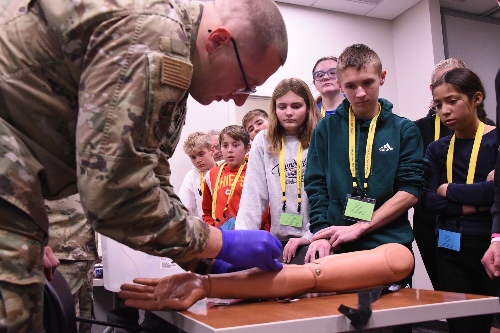 U.S. Air National Guard Tech. Sgt. Daniel Hinds starts IV catheter on simulation arm in front of students