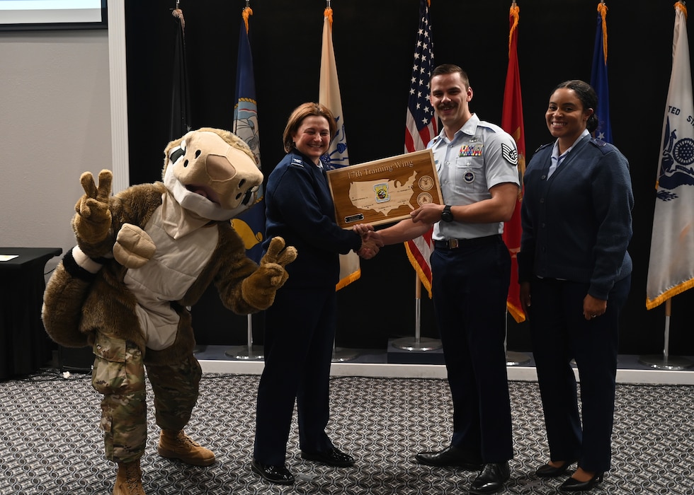 U.S. Air Force Col. Angelina Maguinness, 17th Training Wing commander, presents Tech. Sgt. Nicolaus Hucal, 315th Training Squadron instructor, with the Noncommissioned Officer of the Quarter Award at Goodfellow Air Force Base, Texas, Nov. 9, 2023. Quarterly awards are a tradition that honors exceptional individuals for their outstanding contributions to the 17th TRW mission. (U.S. Air Force photo by Senior Airman Ethan Sherwood)