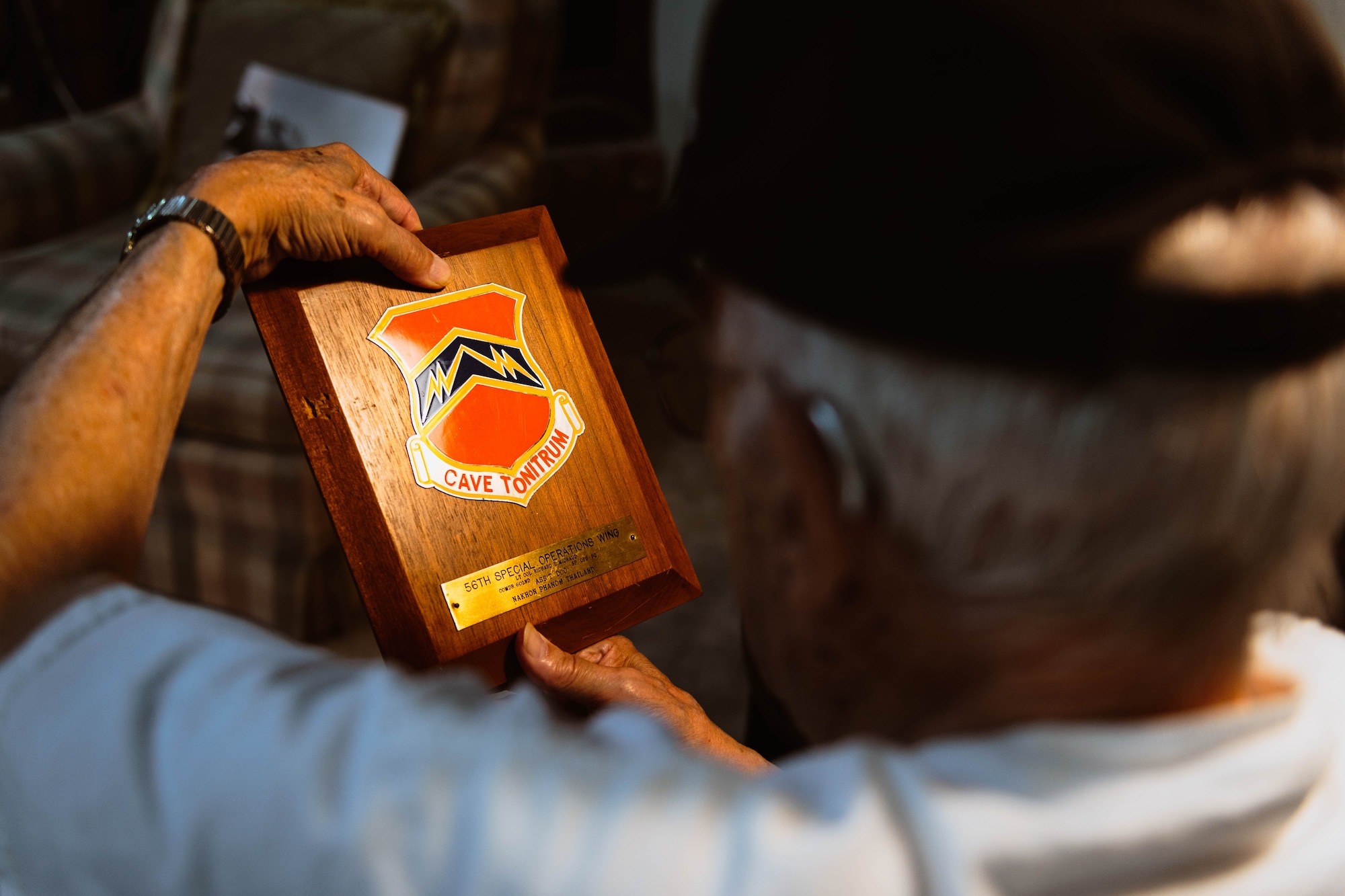 Retired U.S. Air Force Lt. Col. Richard Earl Michaud holds a plaque commemorating his service at the 56th Special Operations Wing.