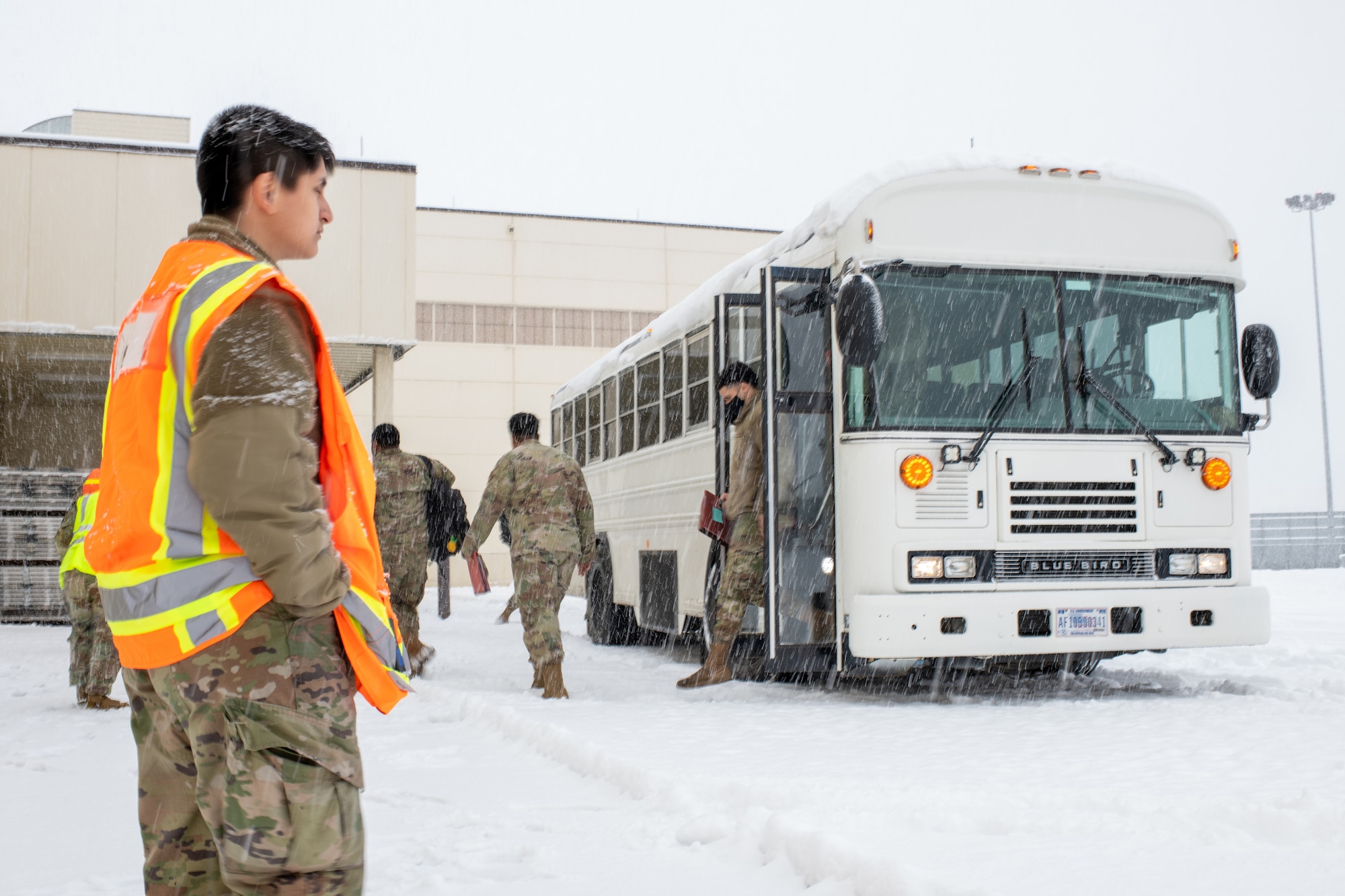 U.S. Air Force Senior Airman Rudy Johnson, assigned to the command element of 773d Logistics Readiness Squadron, watches Airmen disembark from a bus at the Joint Mobility Complex on Joint Base Elmendorf-Richardson, Alaska, Nov. 6, 2023.