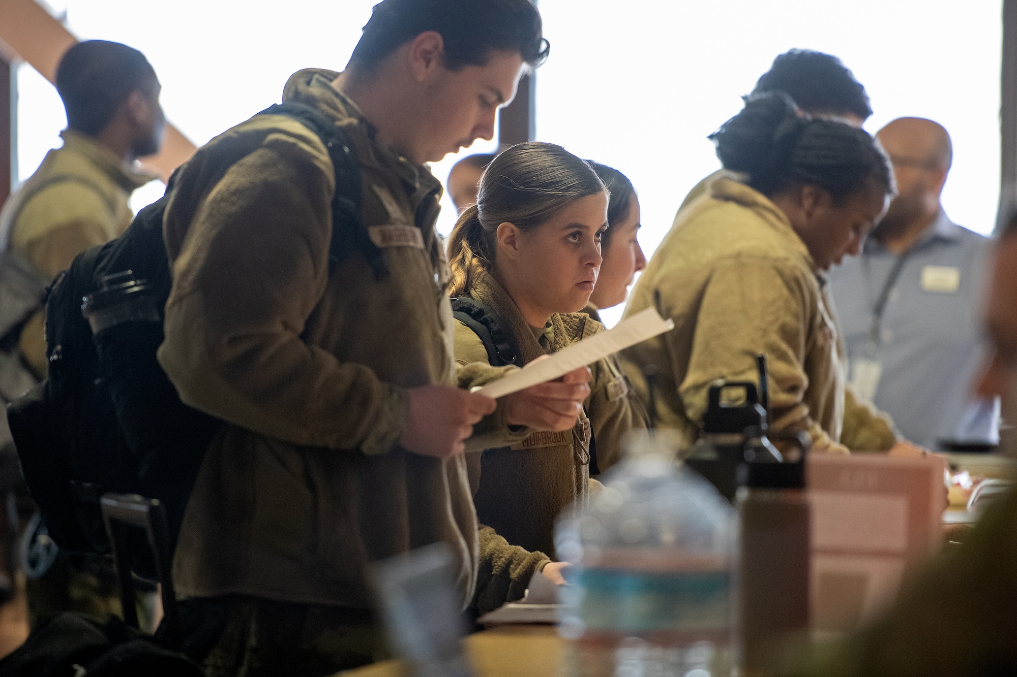 Senior Airman Jayce Muirbrook, a services apprentice assigned to 673d Force Support Squadron, is guided through a line at the Joint Mobility Complex on Joint Base Elmendorf-Richardson, Alaska, Nov. 6, 2023.