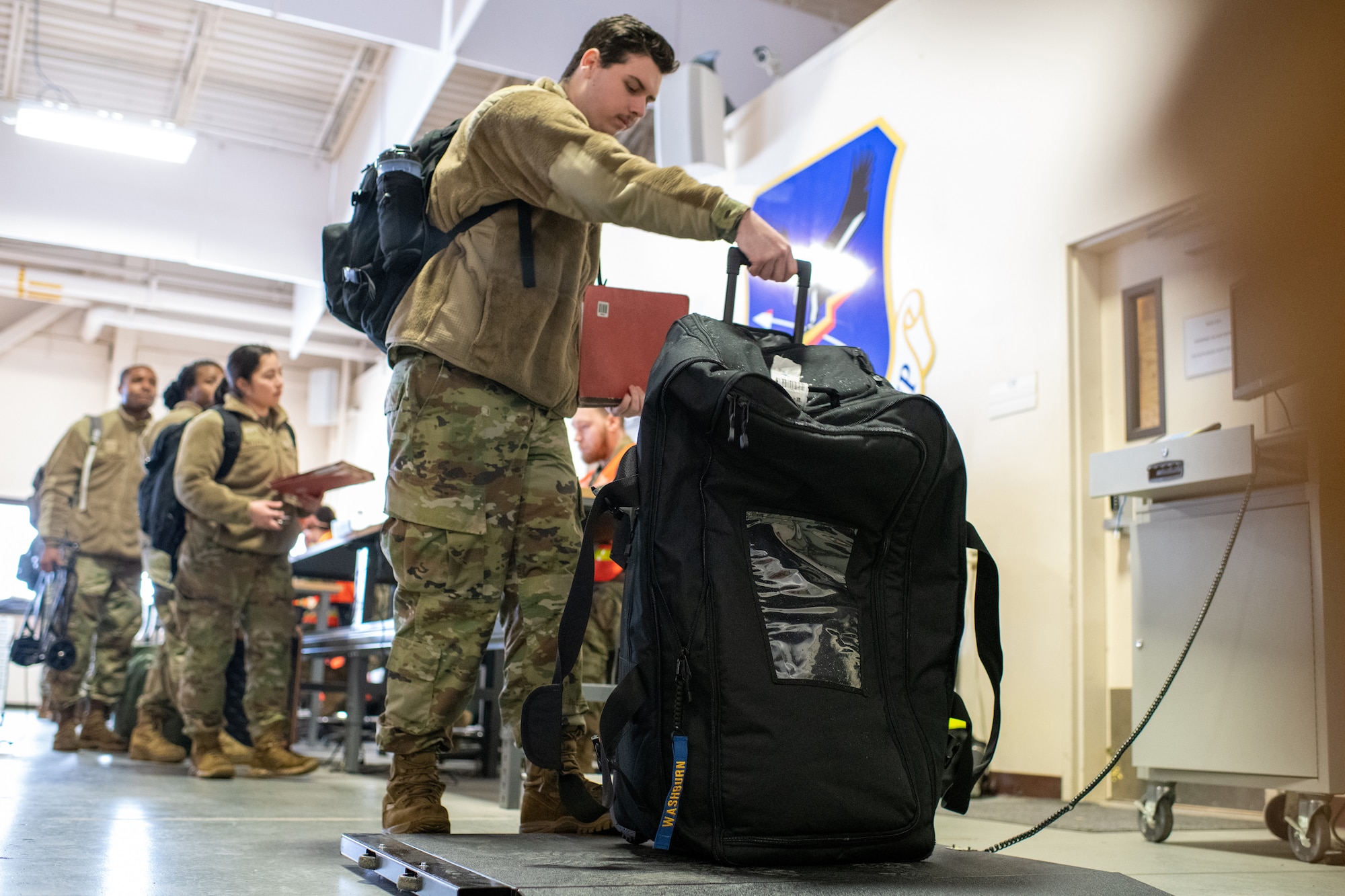 U.S. Air Force Airman Nicholaus Washburn, a services apprentice assigned to the 673d Force Support Squadron, weighs his bag at the Joint Mobility Complex on Joint Base Elmendorf-Richardson, Alaska, Nov. 6, 2023.