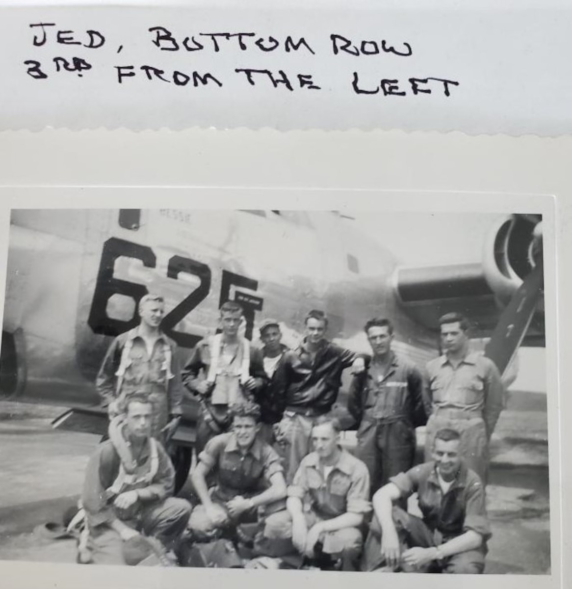 Group of Airman in front of aircraft in old photo.