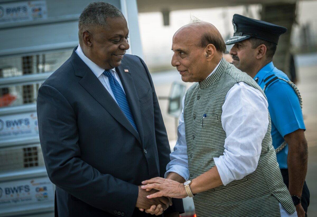 Two men shake hands.