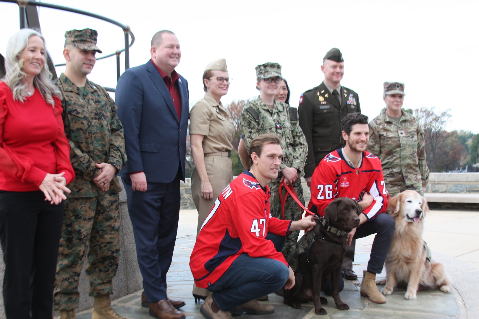 Biscuit, a chocolate-colored Labrador Retriever, is congratulated by Walter Reed leadership, service members, Washington Capitals players and others upon joining the Walter Reed Facility Dog Program and being awarded  the honorary title of U.S. Marine Corps Corporal during an enlistment ceremony on Tuesday, Nov. 7, at Walter Reed.