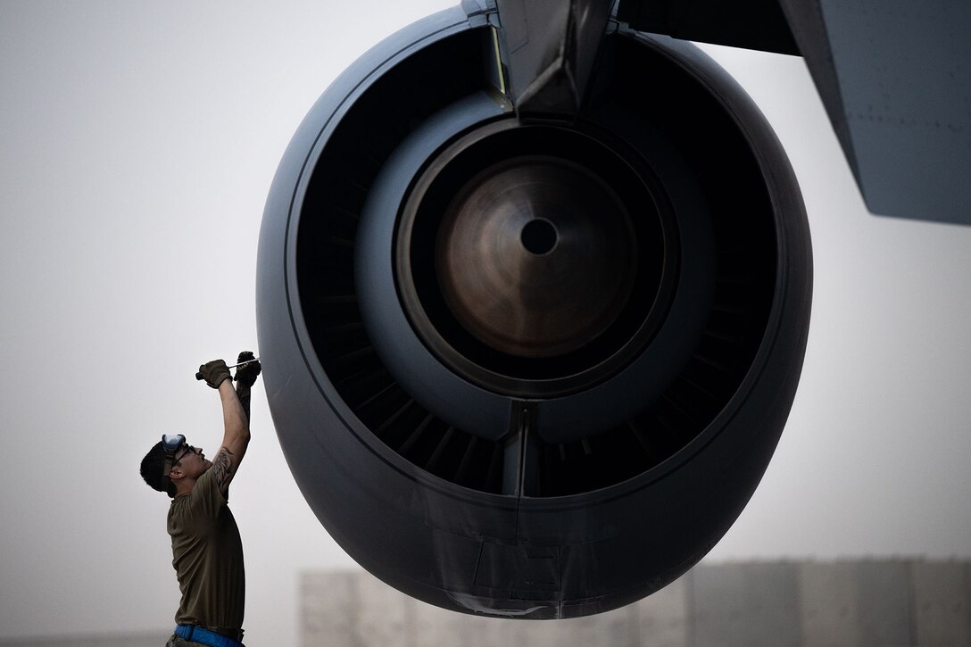 An airman performs a post-flight inspection of an aircraft.