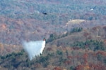 Two Virginia National Guard UH-60 Black Hawk helicopters equipped with 660-gallon water buckets help fight fires Nov. 11, 2023, in Patrick County, Virginia. Aviation crews assigned to the 2nd Battalion, 224th Aviation Regiment, 29th Infantry Division, coordinated efforts with the Virginia Department of Forestry.