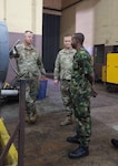 Maj. Jacob Stommen and Maj. Craig Warn, 217th Air Component Operations Squadron maintenance officers, Michigan Air National Guard, speak to a Nigerian Air Force member Sept. 5, 2023, in Nigeria during an airworthiness assessment.