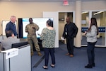 People congregate in front of a white board in an office space.