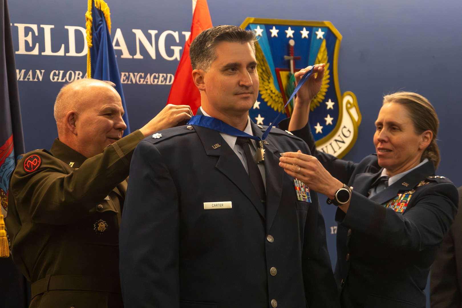 U.S. Air Force Lt. Col. Joshua Carter, the director of the 174th Operations Support Squadron's commander's action group, is presented with the New York State Medal for Valor during an award ceremony at Hancock Field Air National Guard Base in Syracuse Nov. 8, 2023. Carter received the award for his lifesaving actions while responding to a car accident last year. Maj. Gen. Raymond Shields, New York adjutant general, and Maj. Gen. Denise Donnell, commander of the New York Air National Guard, presented the award.