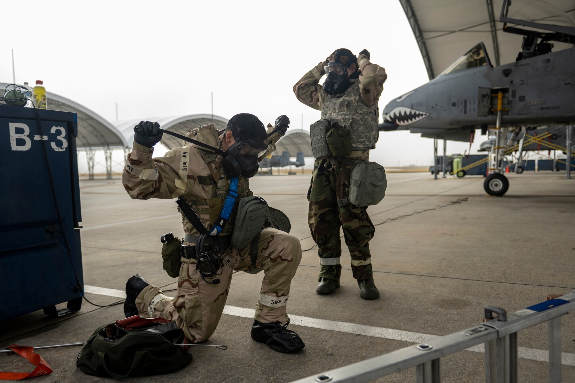U.S. Air Force Senior Airman Andrew Vasquez, left, and Airman Gabrielle Shipley, 74th Fighter Generation Squadron crew chiefs, don Mission Oriented Protective Posture (MOPP) gear at Moody Air Force Base, Georgia, Nov. 9, 2023.