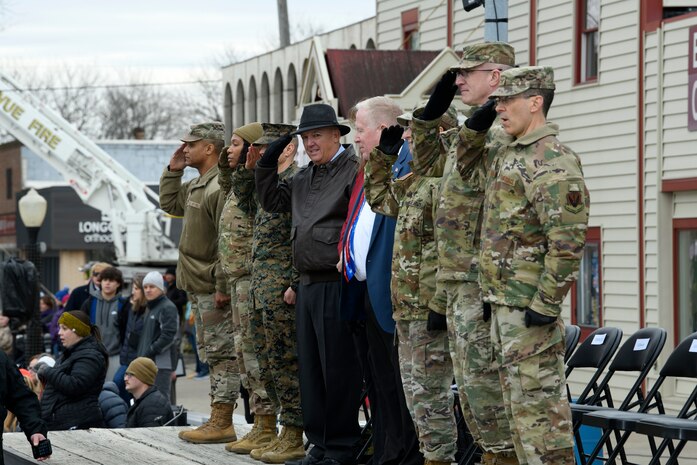 Uniformed personnel in line salute passers by in Veterans Day Parade
