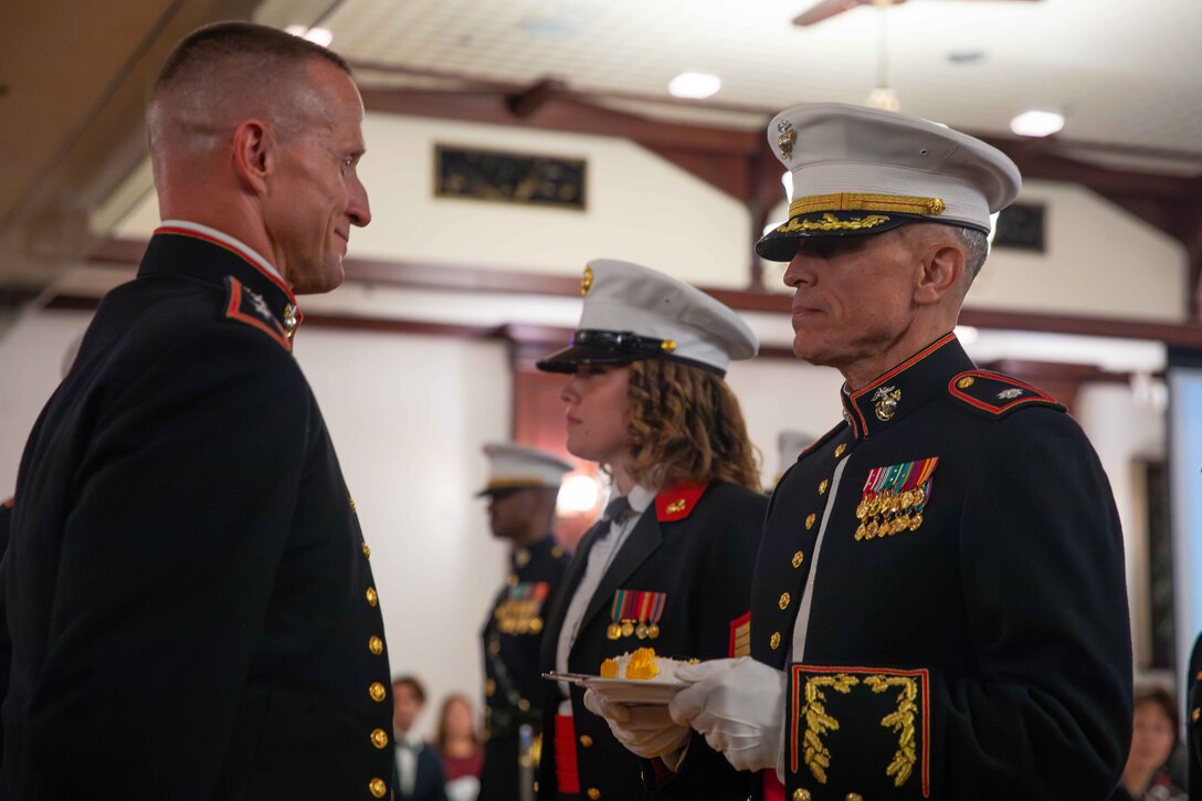 U.S. Marine Corps Maj. Gen. Stephen E. Liszewski, left, commanding general of Marine Corps Installations Pacific, passes the birthday cake to Lt. Col. Brian Clemens, right, deputy operations officer, MCIPAC, the oldest Marine in attendance, during the MCIPAC Marine Corps Birthday Ball at the Butler Officers Club, Okinawa, Japan, Nov. 3, 2023. The Marine Corps birthday ceremony honors the history, legacy and traditions passed down from generation to generation since the founding of the Corps on Nov. 10, 1775. (U.S. Marine Corps photo by Cpl. Martha Linares)