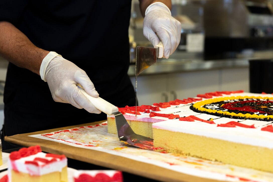 A master labor contractor with Marine Corps Installations Pacific, serves cake for attendees during the 248th Marine Corps’ Birthday Meal on Camp Foster, Okinawa, Japan, Nov. 9, 2023. U.S. Marines with MCIPAC prepared a full course meal for all visitors that included lobster, steak, cake, and a variety of other special menu items. (U.S. Marine Corps photo by Cpl. Thomas Sheng)