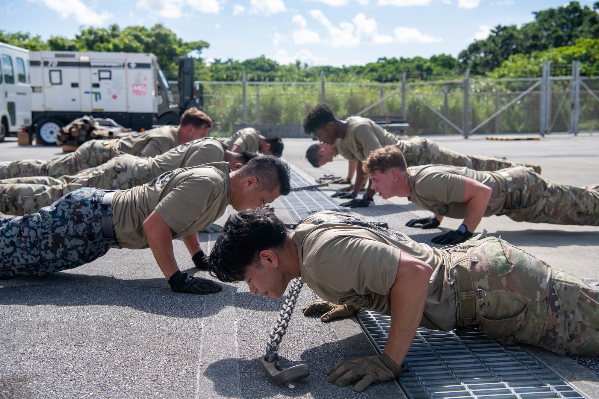 Japan Air Self-Defense Force member and 733rd Air Mobility Squadron preform push-ups for physical training