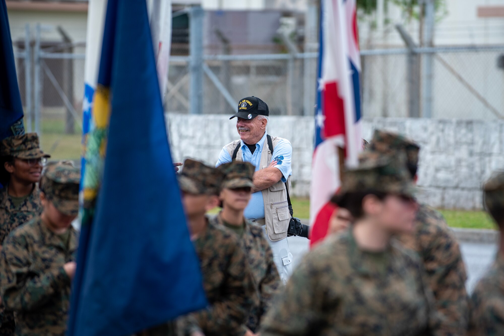 A retired instructor watches as members from Kubasaki Marine Corps JROTC program march by as a part of Kadena Air Base's Veterans Day Parade