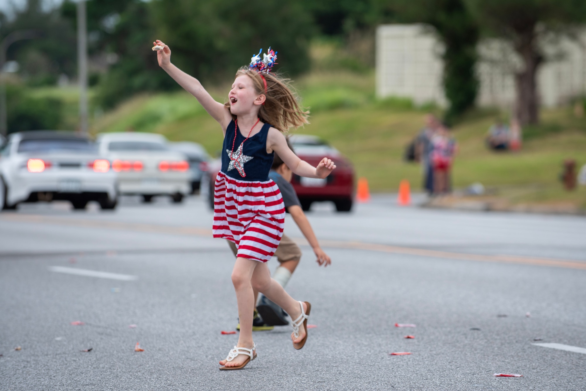 A girl picks up candy tossed from a parade float during Kadena Air Base's Veterans day parade