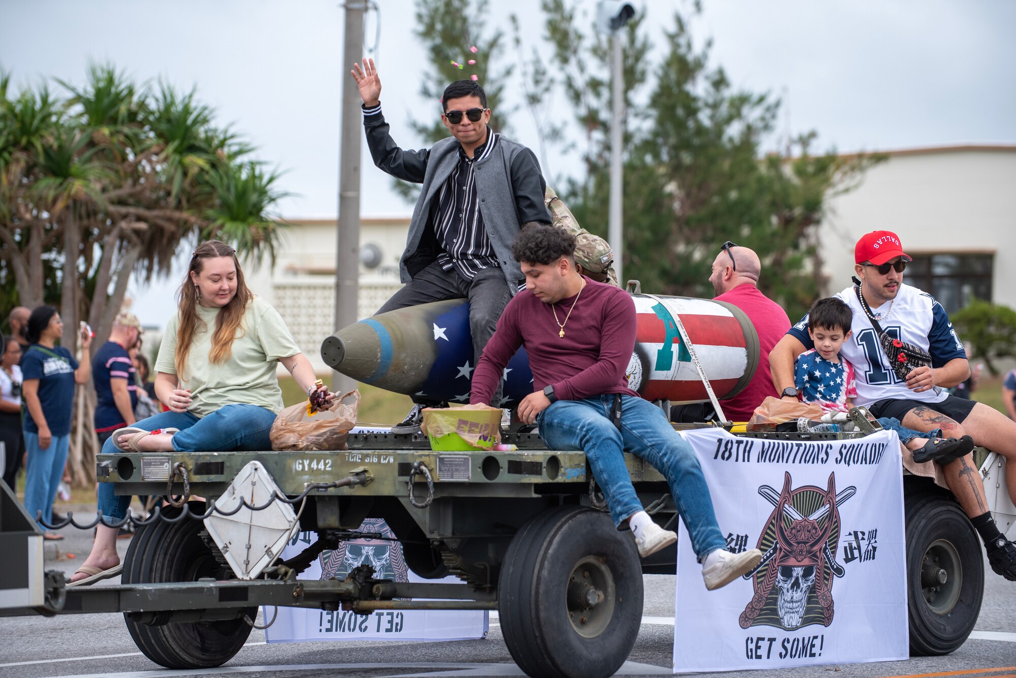 Participants in Kadena Air Base's Veterans day parade wave and throw candy to spectators as they pass by