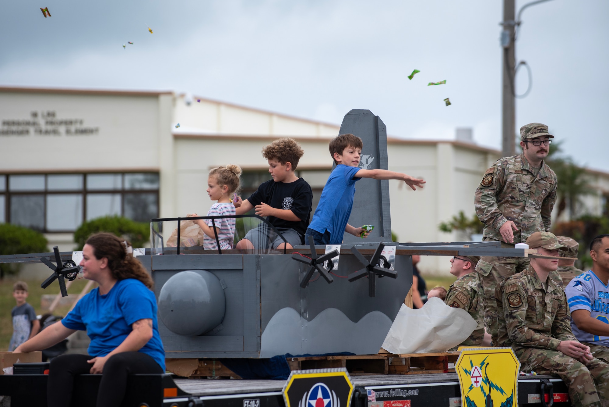 Kids throw candy from a parade float during a Veteran's day parade.