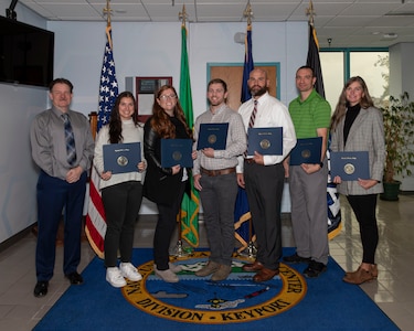 Naval Undersea Warfare Center Division, Keyport Deputy Technical Director Michael Slater celebrates with the inaugural graduates of the Naval Postgraduate School’s “Implementing Technology Change” certificate program.