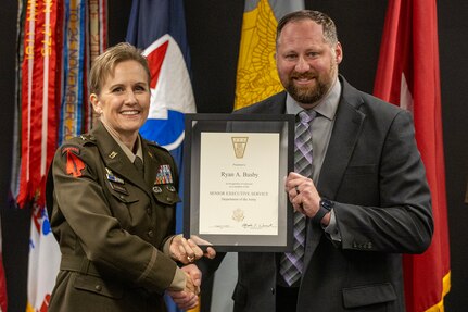 Brig. Gen. Paige M. Jennings, U.S. Army Financial Management Command commanding general, presents Ryan A. Busby, USAFMCOM deputy to the commanding general, his Senior Executive Service certificate at the Maj. Gen. Emmett J. Bean Federal Center in Indianapolis Nov. 2, 2023. The SES was established to ensure that the executive management of the government of the United States is responsive to the needs, policies and goals of the nation and otherwise is of the highest quality. (U.S Army photo by Mark R. W. Orders-Woempner)