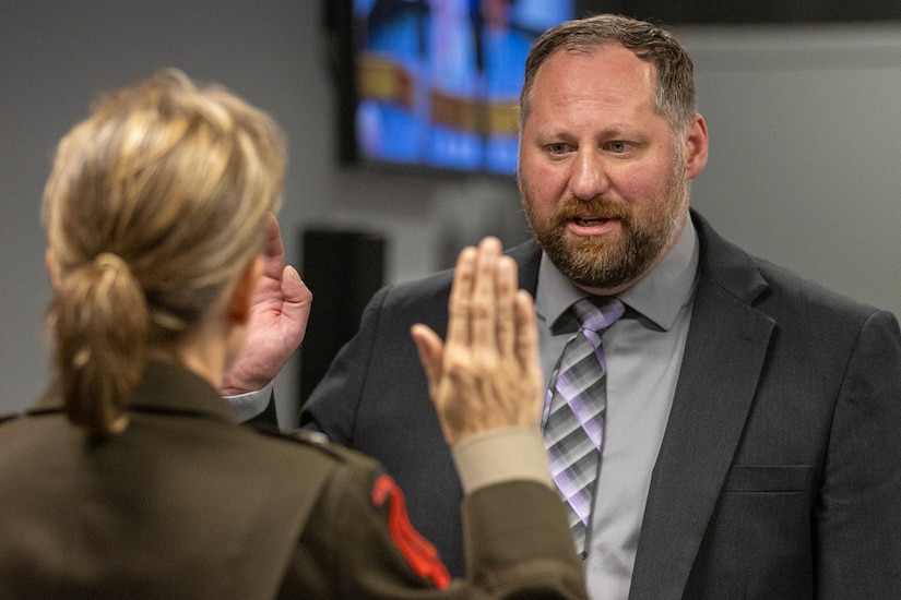 Brig. Gen. Paige M. Jennings, U.S. Army Financial Management Command commanding general, administers an oath of office to Ryan A. Busby, USAFMCOM deputy to the commanding general, during his Senior Executive Service induction ceremony at the Maj. Gen. Emmett J. Bean Federal Center in Indianapolis Nov. 2, 2023. Busby serves as the principal advisor to the USAFMCOM commanding general, ensuring the two-star command delivers precision, enterprise-wide financial operations to integrate, synchronize and sustain the battlefield through the Joint Strategic Area. (U.S Army photo by Mark R. W. Orders-Woempner)