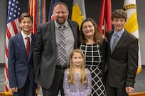 Ryan A. Busby, U.S. Army Financial Management Command deputy to the commanding general, poses with his wife Lisa, Defense Finance and Accounting Service accountant, and their children, Sam, Wes, and Emma during his Senior Executive Service induction ceremony at the Maj. Gen. Emmett J. Bean Federal Center in Indianapolis Nov. 2, 2023. Busby serves as the principal advisor to the USAFMCOM commanding general, ensuring the two-star command delivers precision, enterprise-wide financial operations to integrate, synchronize and sustain the battlefield through the Joint Strategic Area. (U.S Army photo by Mark R. W. Orders-Woempner)